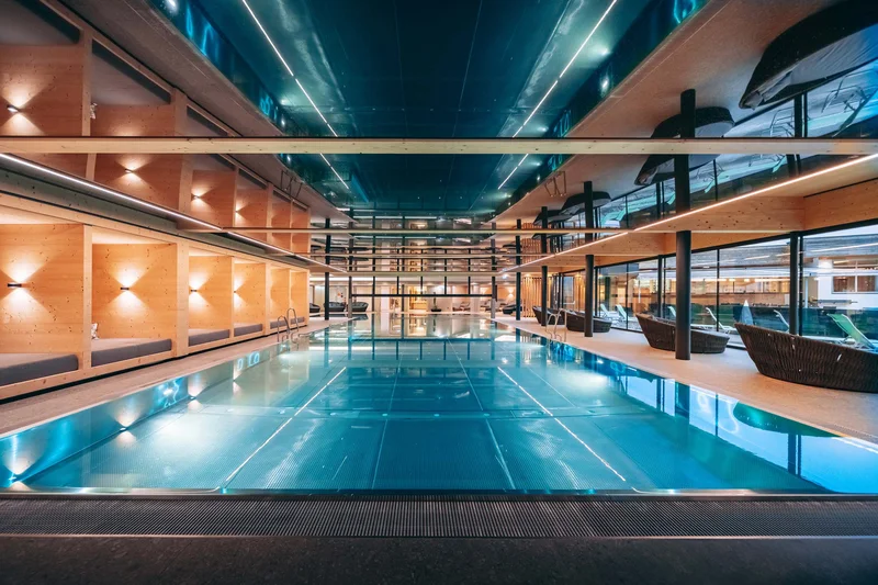 Familienhotel Buchau am Achensee Modernes Innen-Schwimmbad mit Holzverkleidung und Lounge-Bereichen