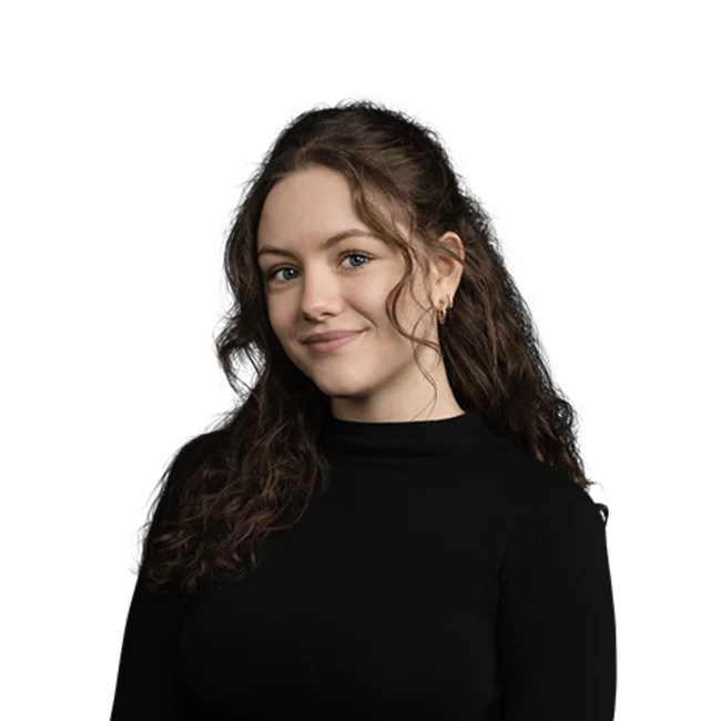 Portrait of a young woman with long curly hair wearing a black sweater