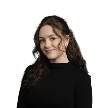 Portrait of a young woman with long curly hair wearing a black sweater