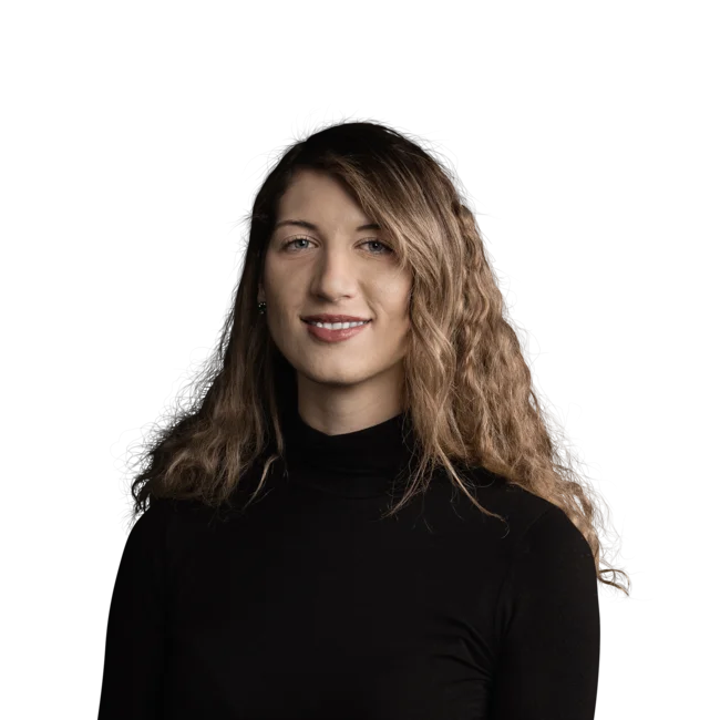 Irene Ferrara Portrait einer lächelnden Frau mit lockigem Haar und schwarzem Rollkragenpullover