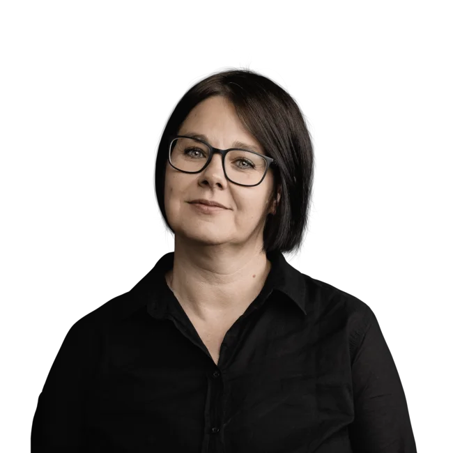 Porträt einer Frau mit kurzen dunklen Haaren und Brille in schwarzem Hemd