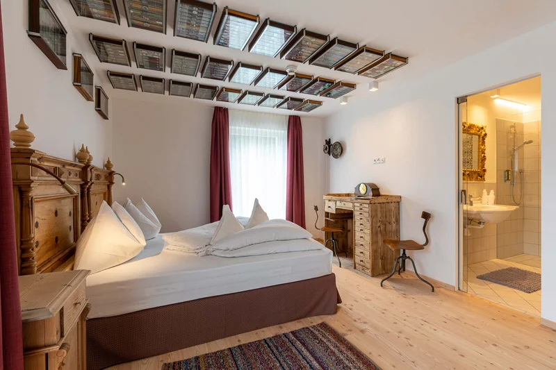 Cozy bedroom with wooden furniture and bathroom with shower