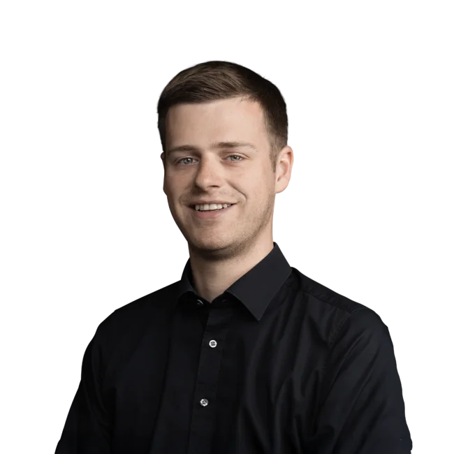 Lächelnder junger Mann mit kurzen braunen Haaren in schwarzem Hemd vor weißem Hintergrund