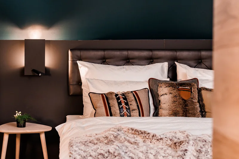 Gemütliches Schlafzimmer mit bedruckten Kissen und warmem Licht