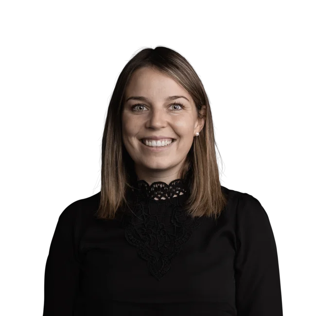 Magdalena Faltner Porträt einer lächelnden Frau mit schwarzer Spitzebluse vor weißem Hintergrund