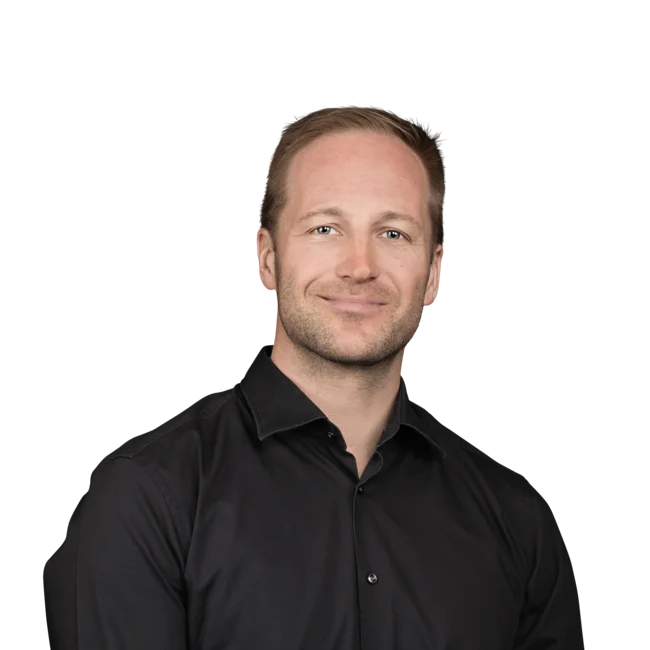 Martin Leitinger Ritratto di un uomo sorridente con camicia nera su sfondo bianco