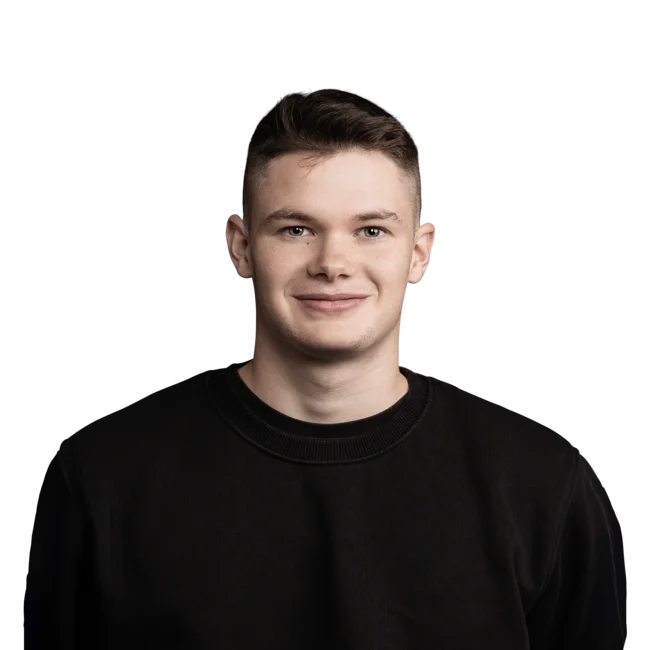 Junger Mann mit kurzem braunem Haar und schwarzem Pullover lächelt