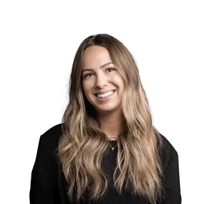 Frau mit langen blonden Haaren und schwarzem Oberteil lächelt freundlich