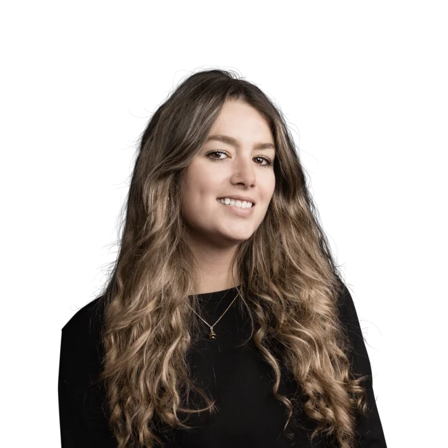 Porträt einer lächelnden jungen Frau mit langen lockigen Haaren vor weißem Hintergrund