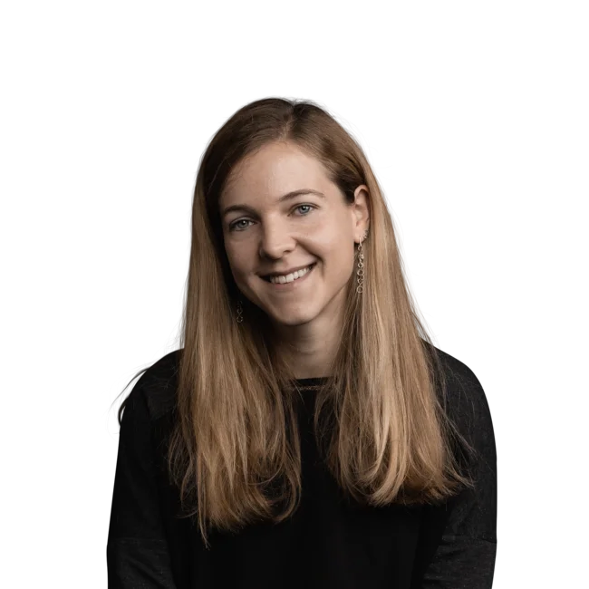 Portrait einer lächelnden jungen Frau mit langen blonden Haaren und schwarzen Pullover