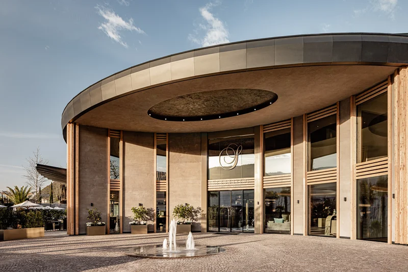 Immerse yourself in Italian dolce vita Entrance of a modern building with glass facade and a fountain