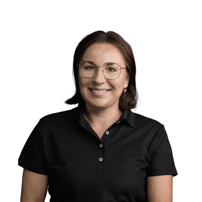 Frau mit kurzen braunen Haaren, Brille und schwarzem Poloshirt, lächelnd