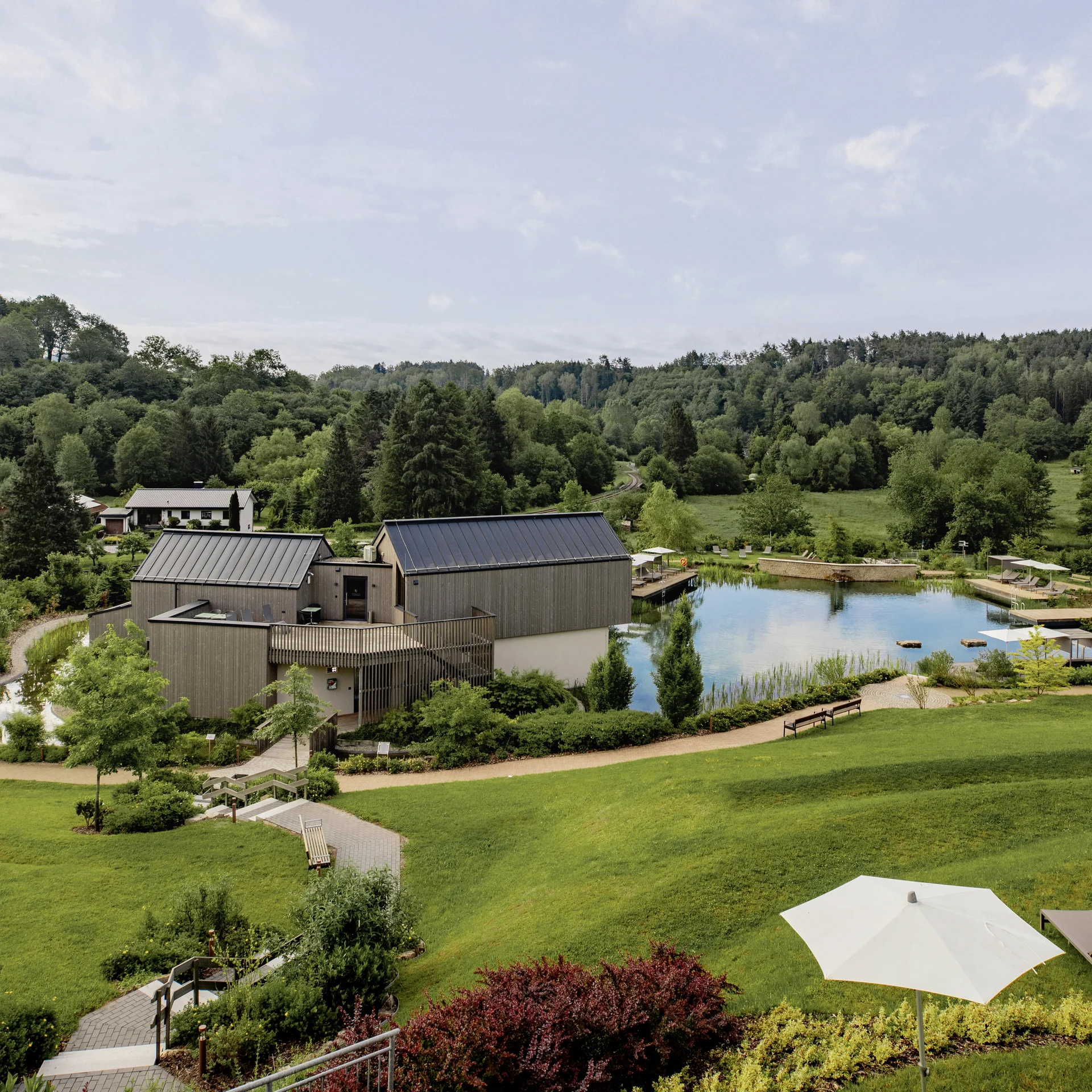 Pfalzblick Wald Spa Resort: posizionamento forte, su internet e fuori Paesaggio con campi verdi, stagno, edifici e cielo azzurro con nuvole