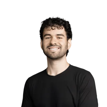 Junger Mann mit lockigem Haar und schwarzem Shirt lächelt freundlich