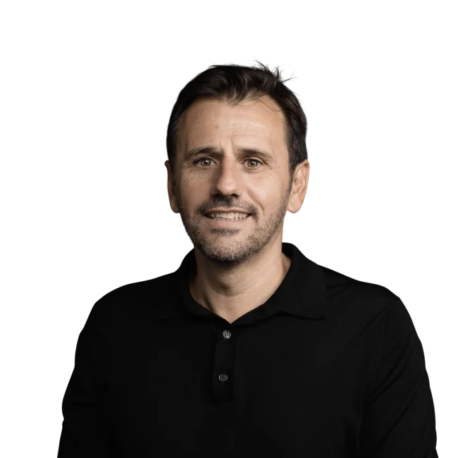 Porträt eines lächelnden Mannes mit dunklem Hemd vor weißem Hintergrund